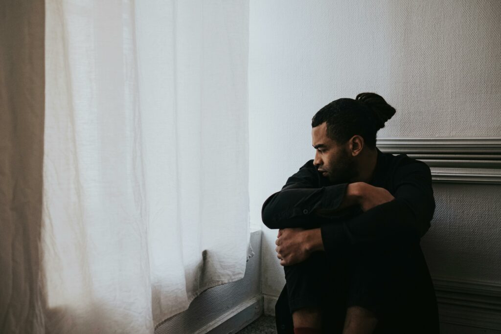Homme assis, visiblement anxieux, les épaules repliées — illustration des troubles anxieux et TOC