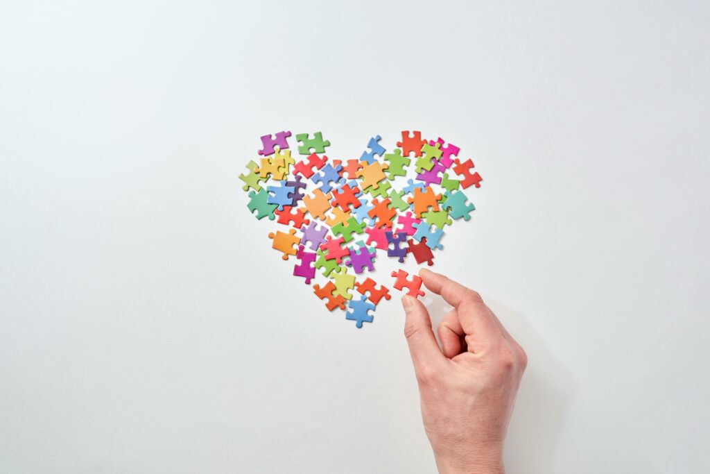 Personne assemblant un puzzle en forme de cœur, image du TOC du couple et du doute relationnel
