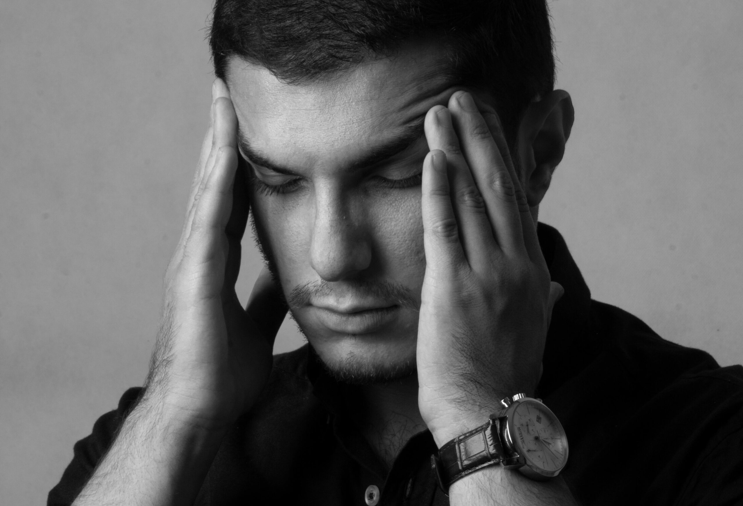 Homme inquiet, les mains sur les tempes, craignant une nouvelle crise d’angoisse