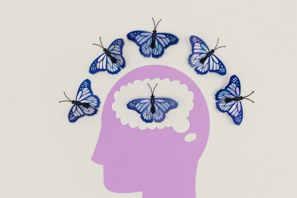 Papillons sortant d’un cerveau, symbolisant la flexibilité psychologique développée avec l’ACT